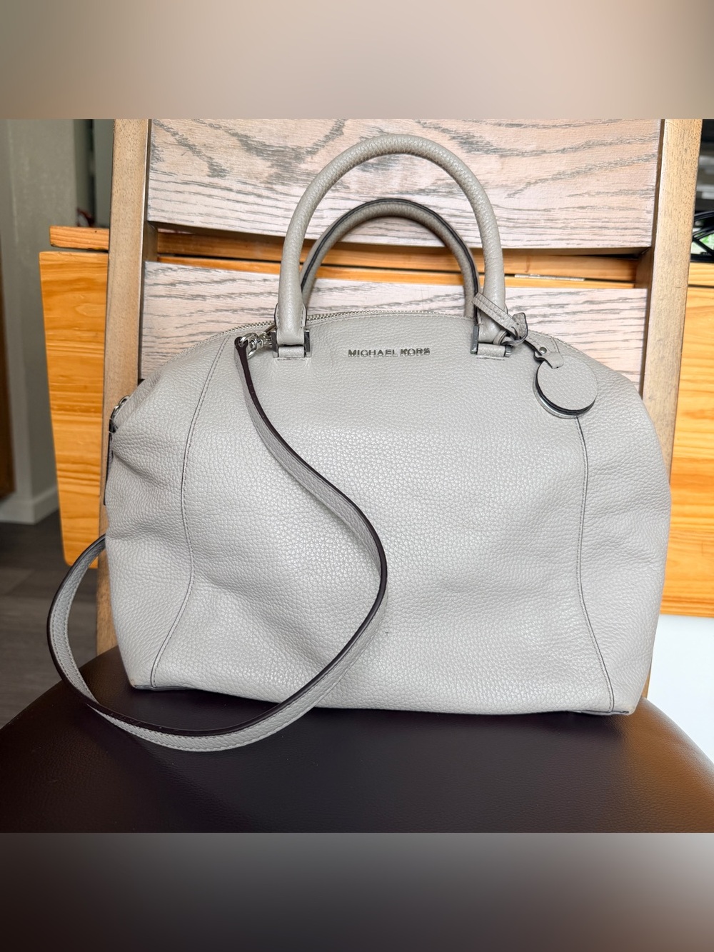 Michael Kors Riley satchel is crafted from pebbled leather in a light grey shade
